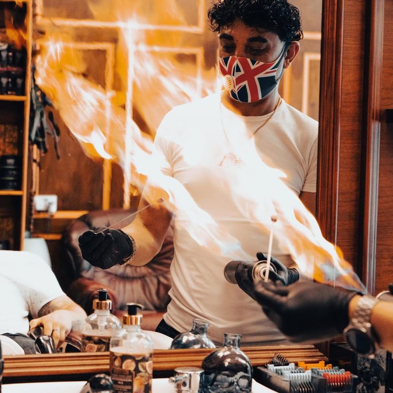 Barber performing a signature flame finishing treatment at Boss Barbers, Bath